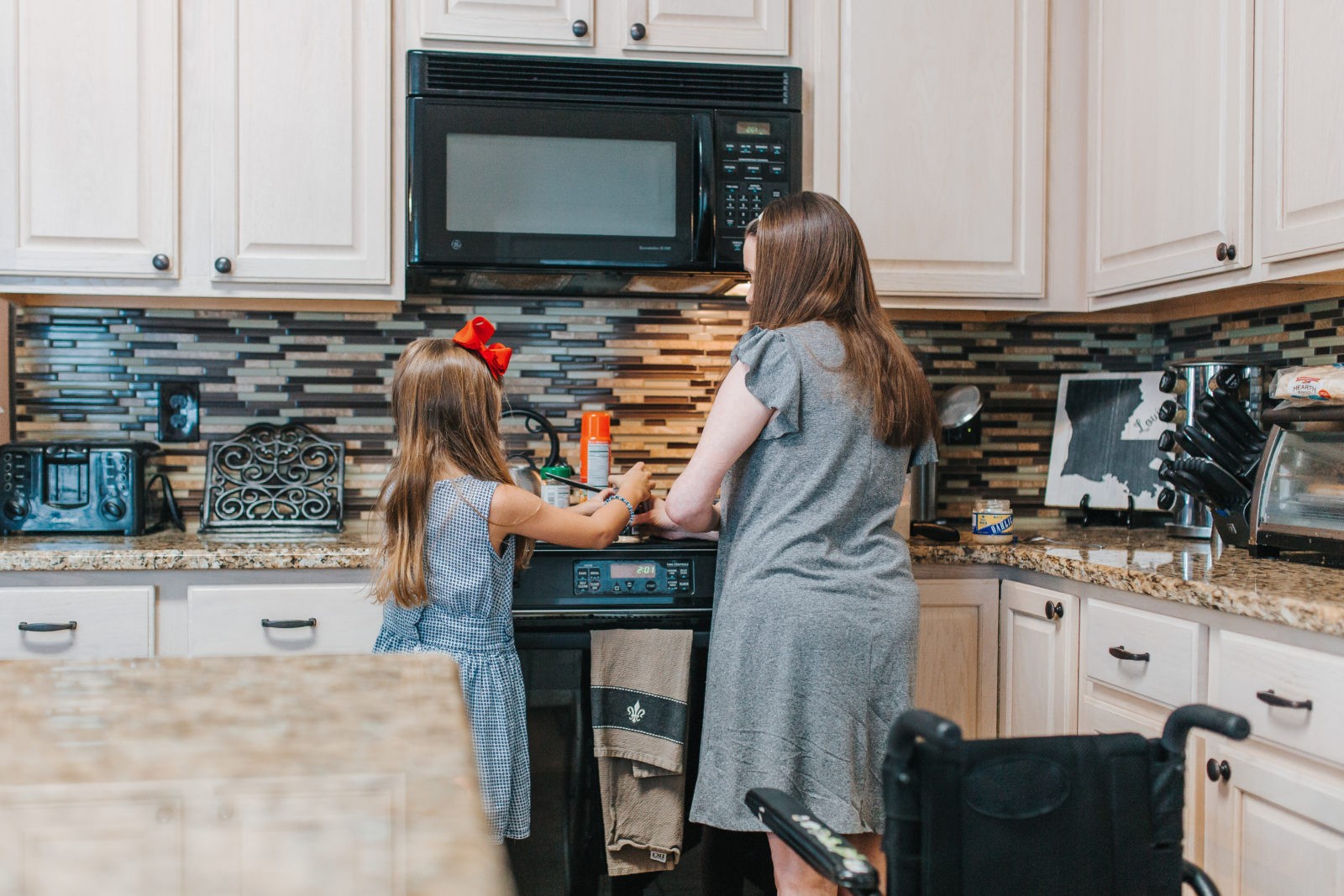 woman cooking with daughter in kitchen