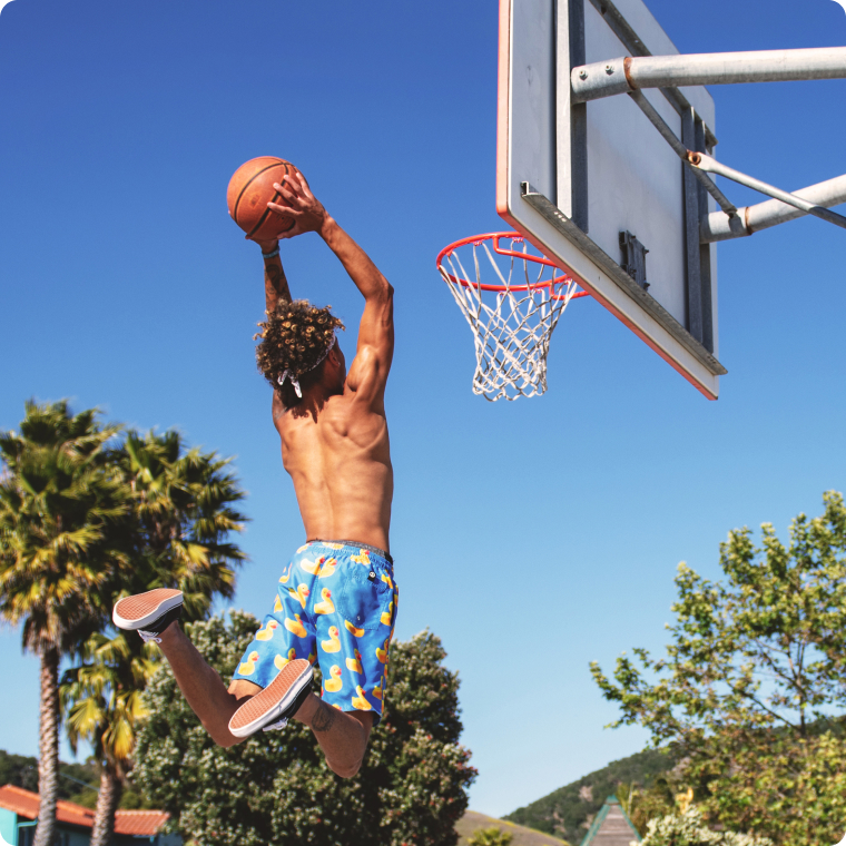 A man jumping to dunk a basketball