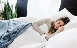 Woman sleeping in a bed with white sheets