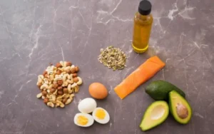 Avocado, eggs, olive oil, salmon on a table