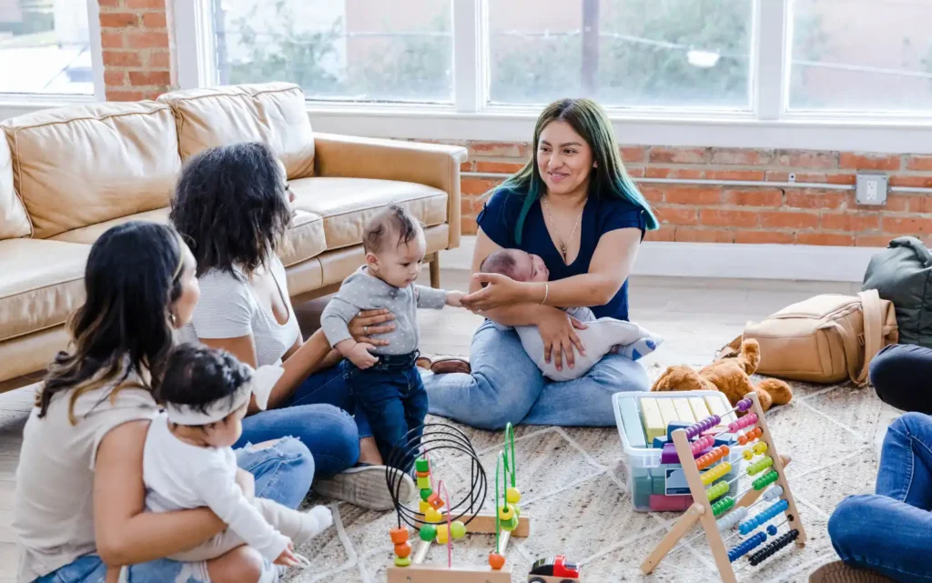 New moms, sitting with their children playing with toys