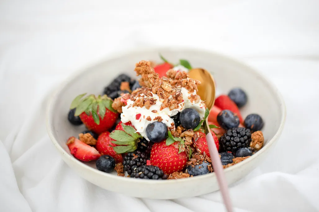 Berries served with cream and crumbles in a bowl