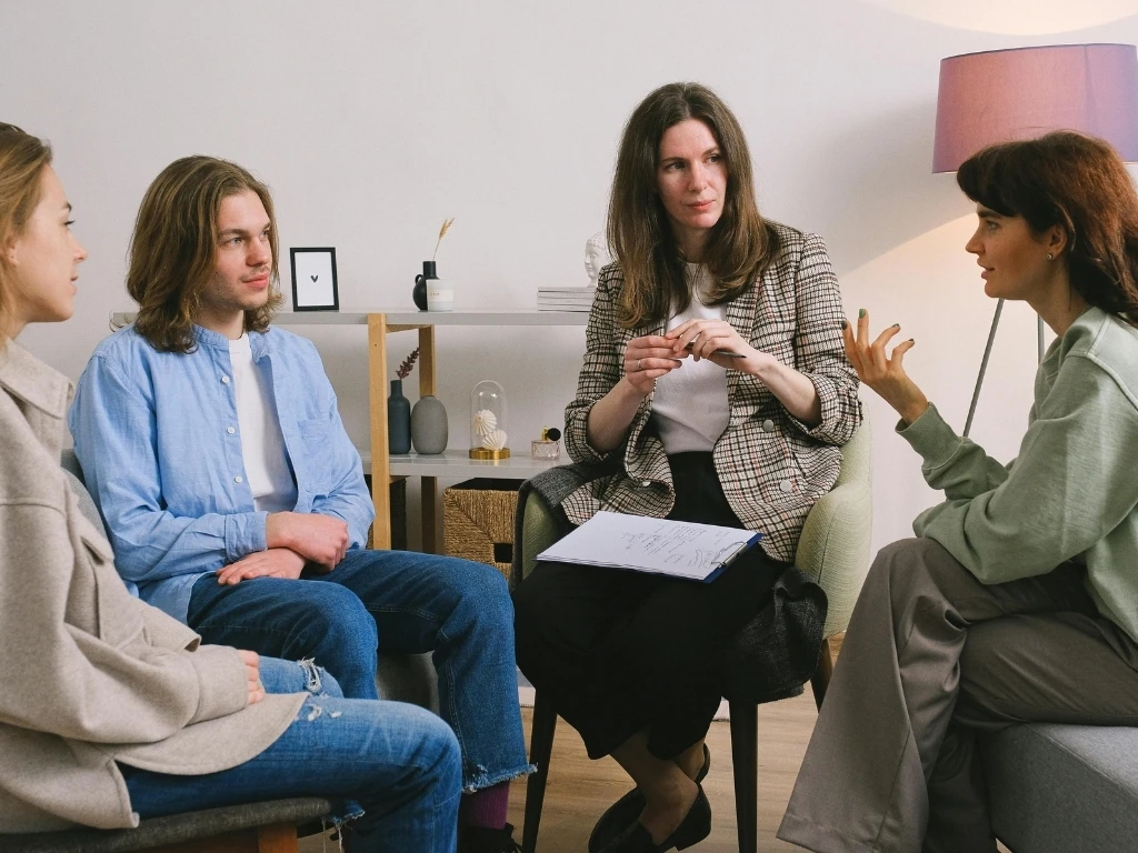A group of four people sitting close together while one person speaks