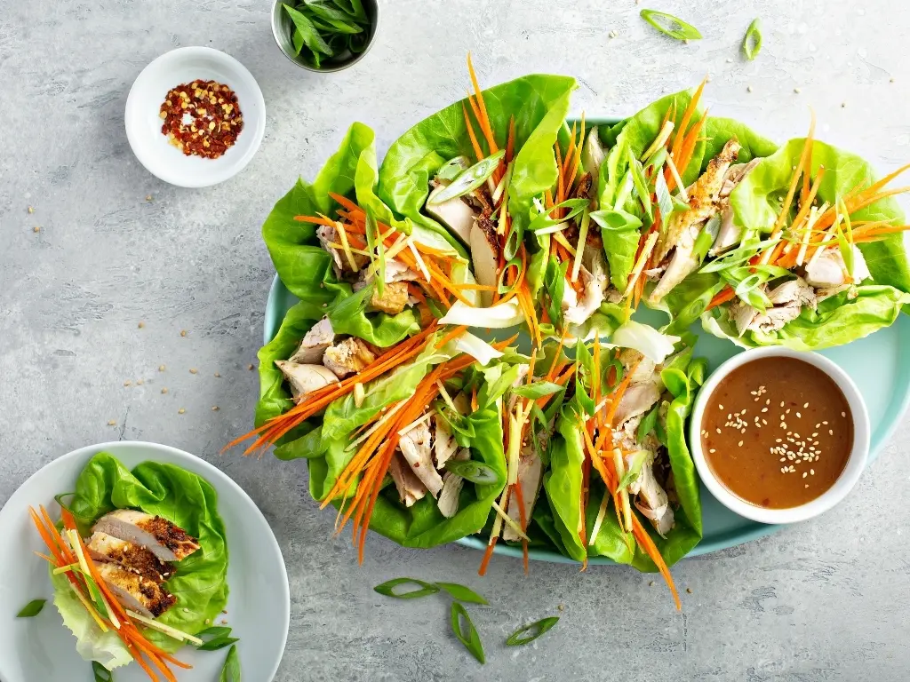 Roasted turkey lettuce wraps with avocado, shredded cabbage, and carrots