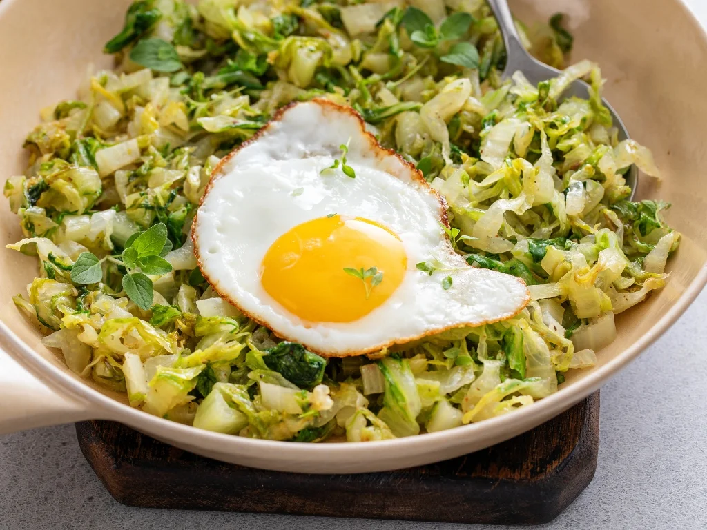 Sauteed cabbage and fried egg in a pan
