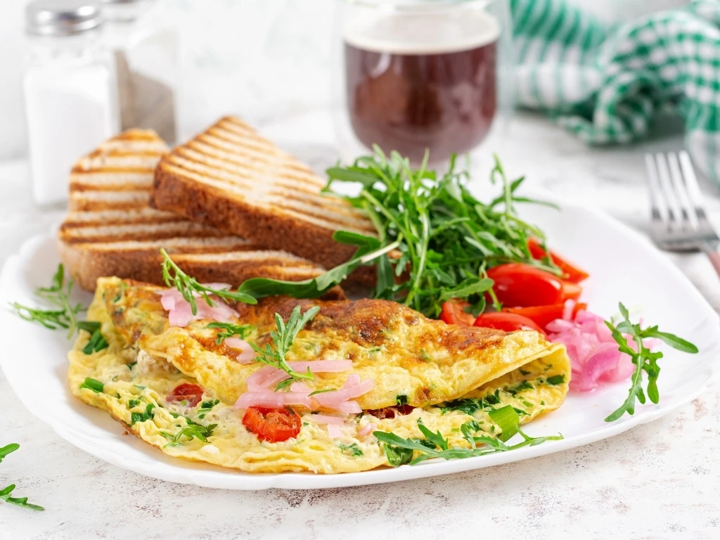 Plate of vegetable omelet with two slices of whole-grain toast