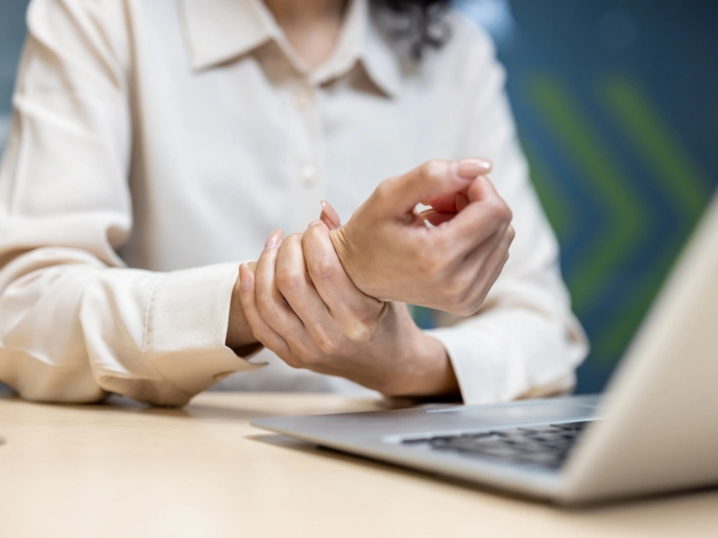 Woman holding her wrist due to joint pain, a common sign of rheumatoid arthritis