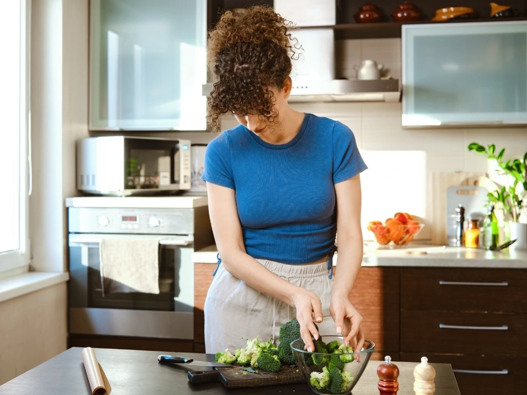 Woman preparing broccoli in the kitchen