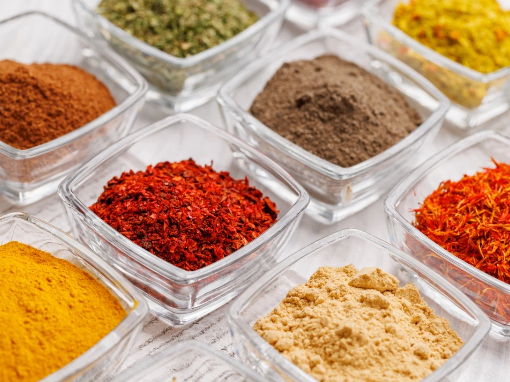 Different spices in small rectangular containers, arranged neatly like a grid