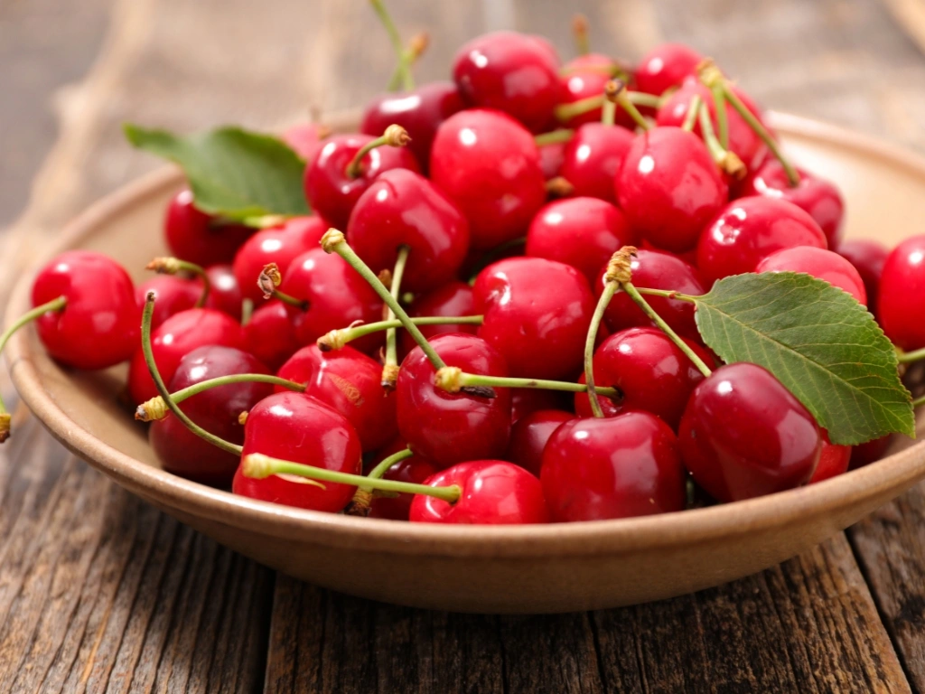 Bowl of fresh cherries on a wooden table