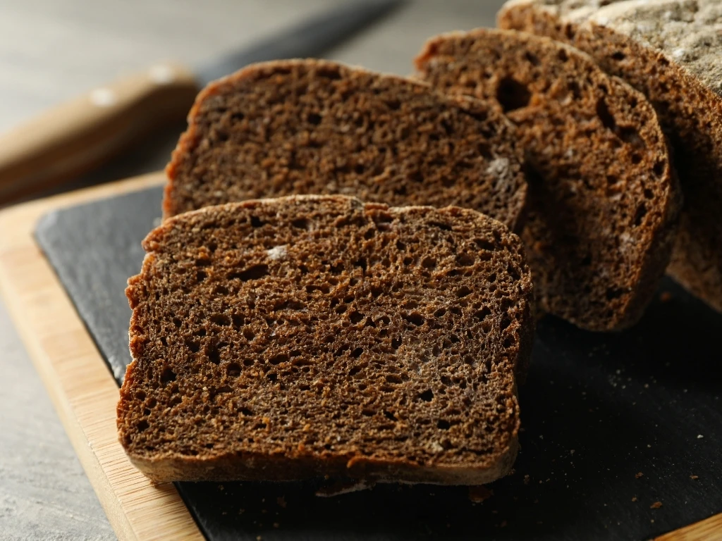 Sliced pumpernickel bread on a board