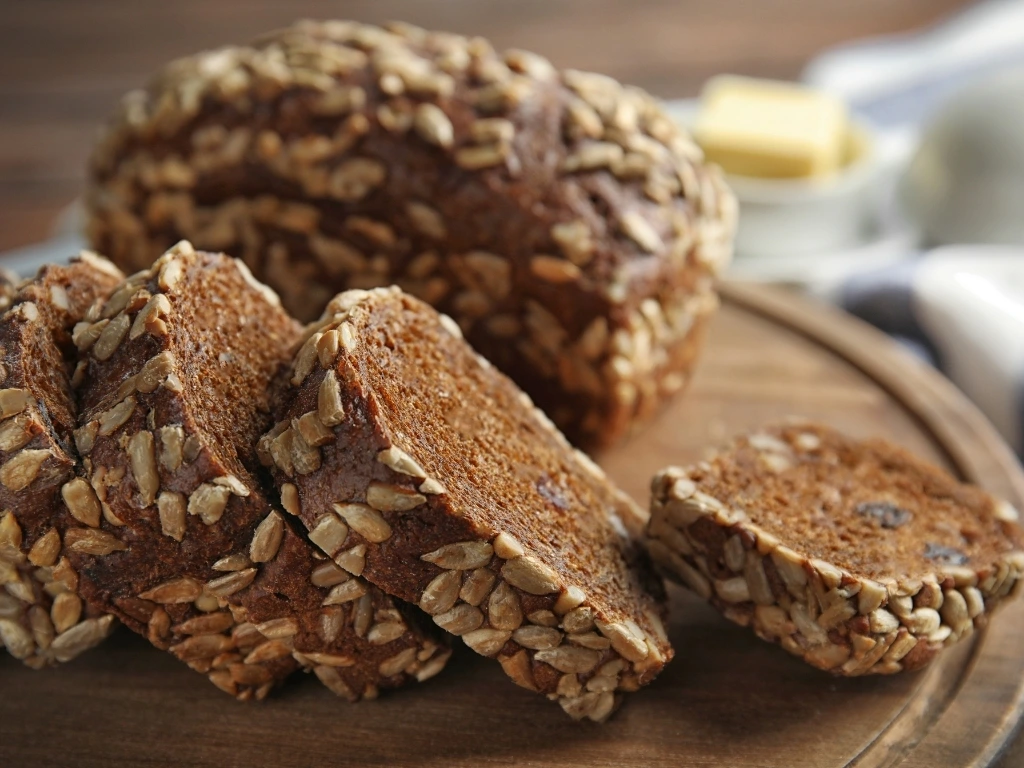 Sliced sunflower seed bread on a round wooden tray