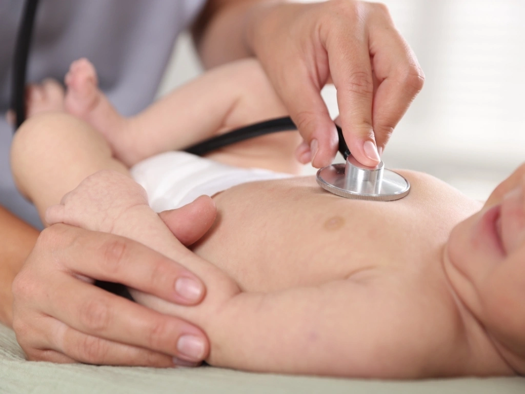 Doctor examining an infant using a stethoscope