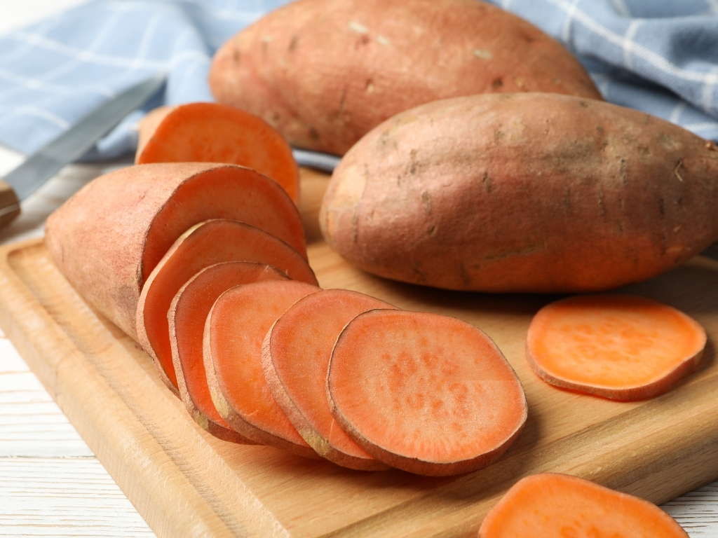 Sliced sweet potatoes on a wooden board
