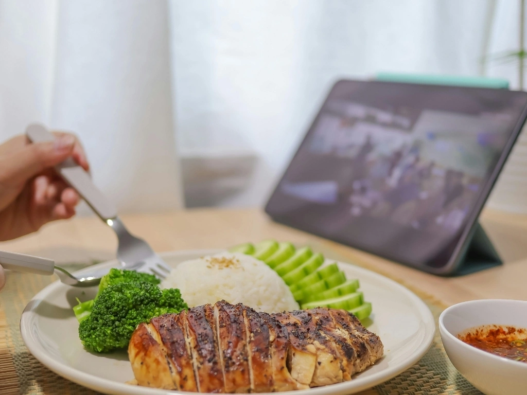Closeup of a Person Eating Dinner and Looking at Laptop Screen