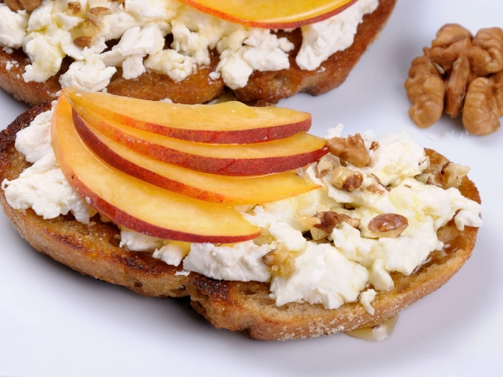 Cottage cheese, sliced peaches, and walnuts on whole-grain toast