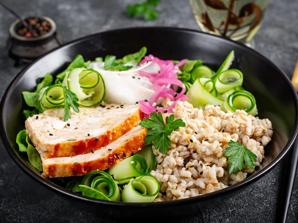 Turkey and vegetable bowl with brown rice, served next to a fork