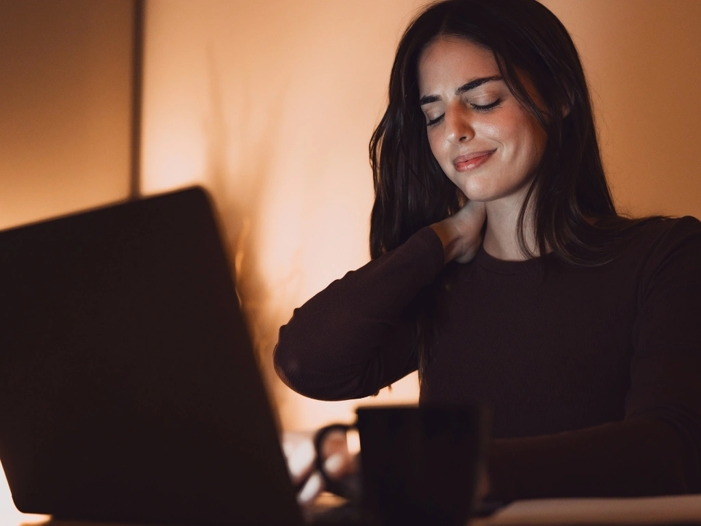 Woman at work holding the nape of her neck due to fatigue