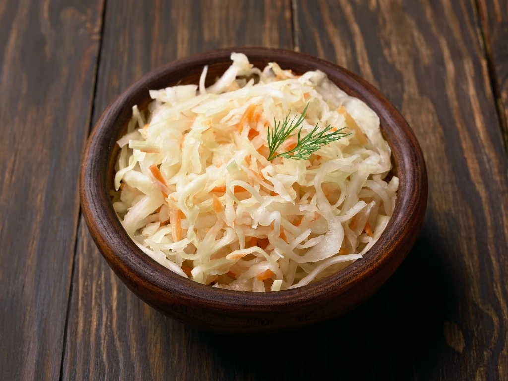 Sauerkraut with carrots in a wooden bowl