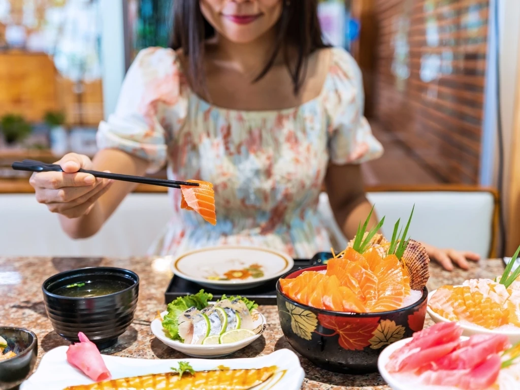 Woman eating different types of raw fish