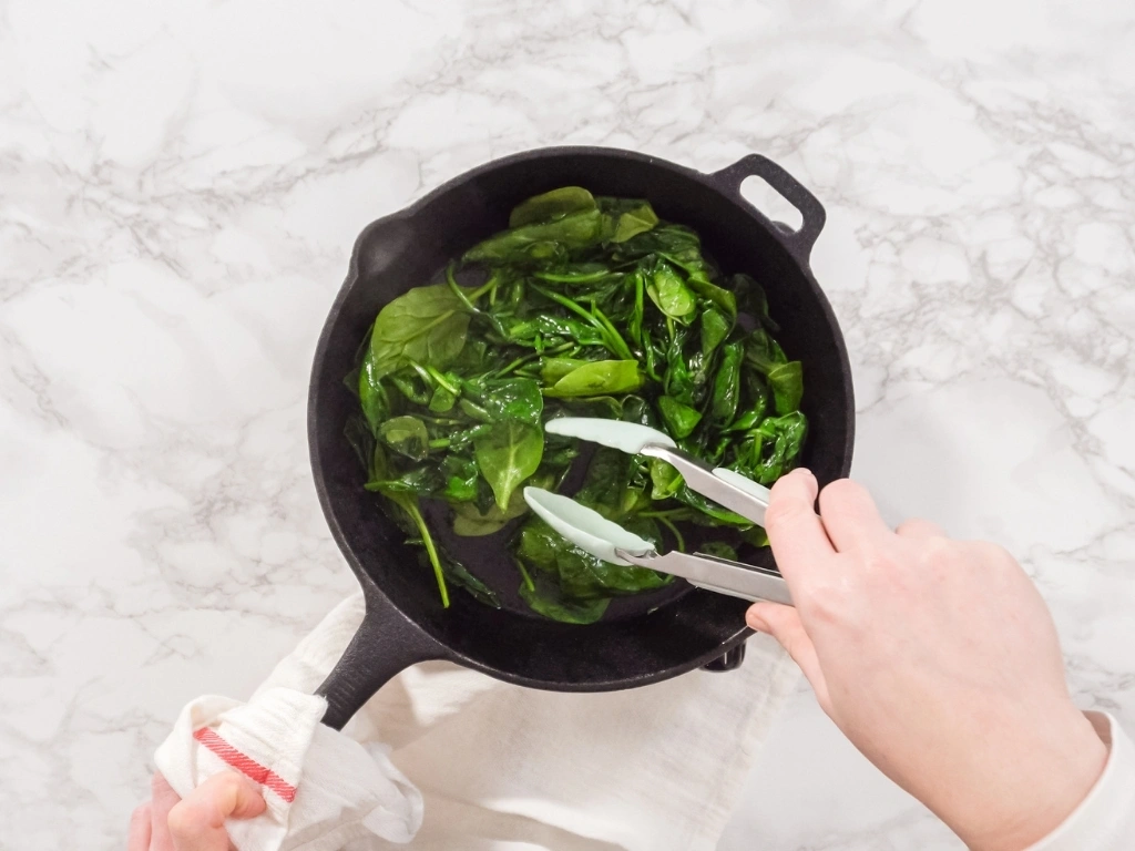 Cooking spinach in a cast-iron skillet