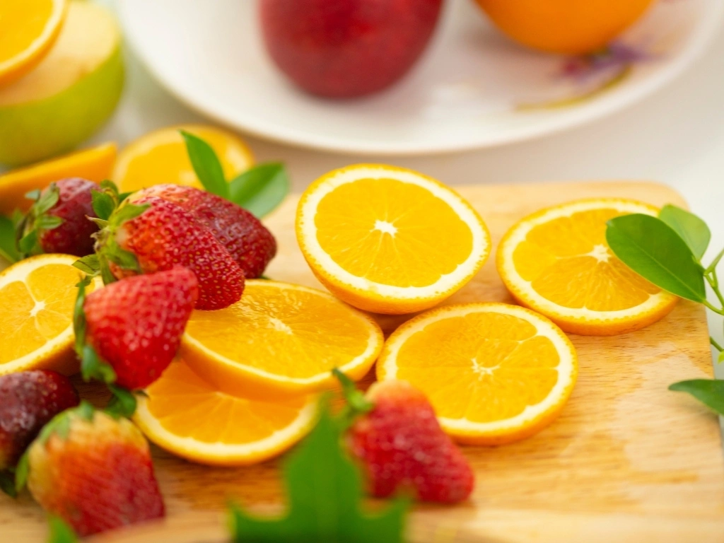 Strawberries and slices of orange on a cutting board