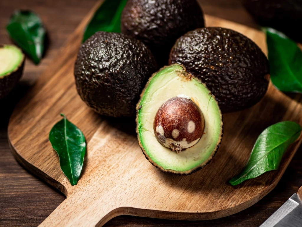 Avocados and leaves on a wooden table