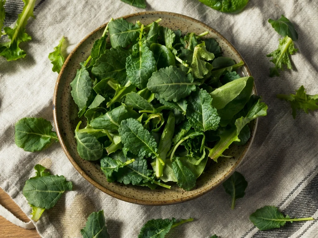 https://healthloftco.com/wp-content/uploads/content-foods-to-lower-blood-sugar.jpg Raw kale in a ceramic bowl and scattered across a tablecloth