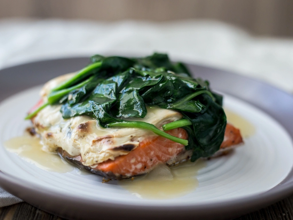 Plate of steamed salmon topped with sautéed spinach