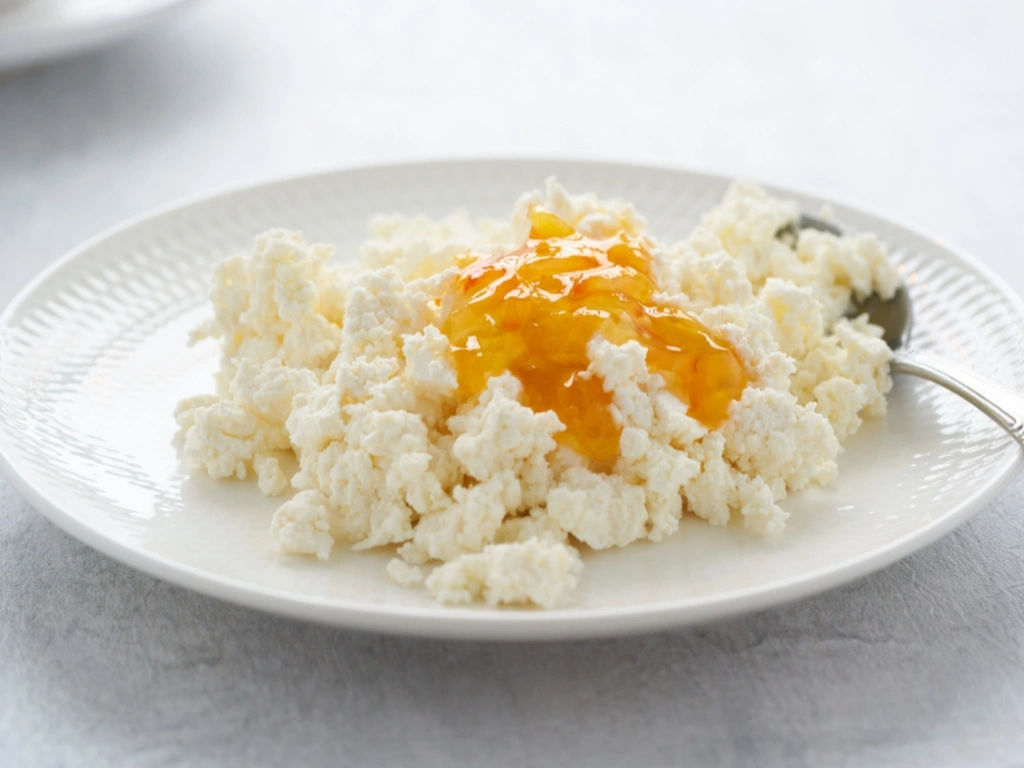 Plate of ricotta with a small amount of applesauce, served with a spoon