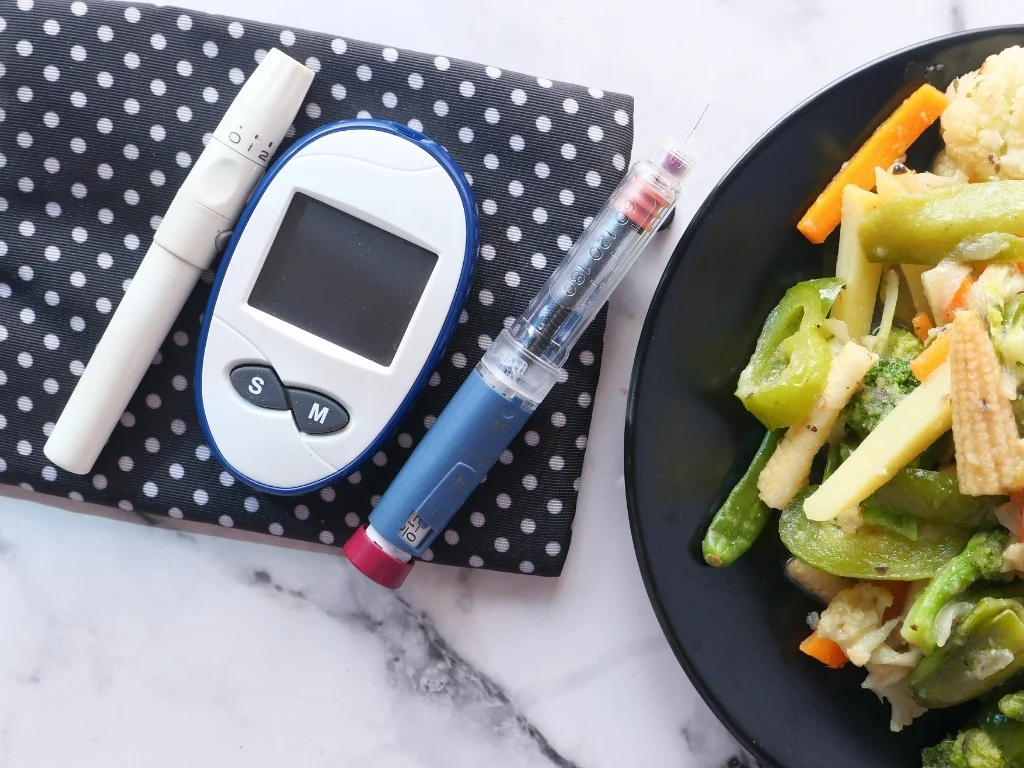 diabetic measurement tools and insulin pen and healthy food on table