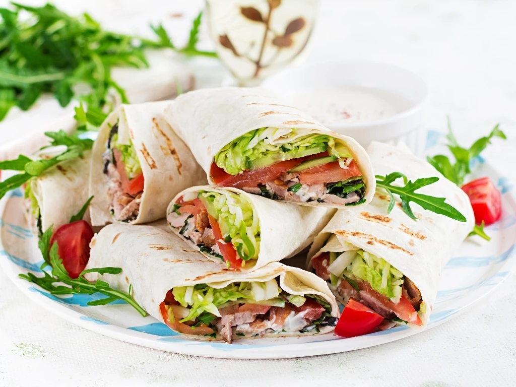 Burritos wraps with beef and vegetables on light background. Beef tortilla, mexican food.