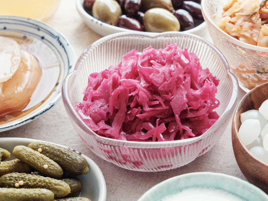 Small bowls of different fermented foods neatly arranged on a surface