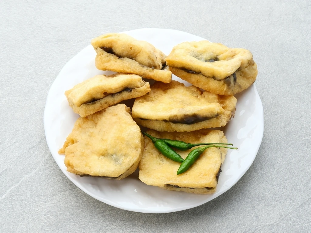 Stuffed tofu served with chili peppers on a white plate