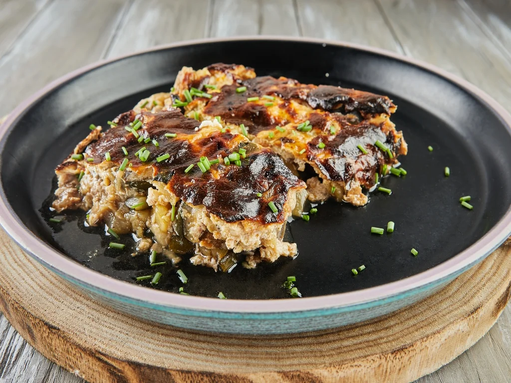 Eggplant and zucchini gratin on a black plate