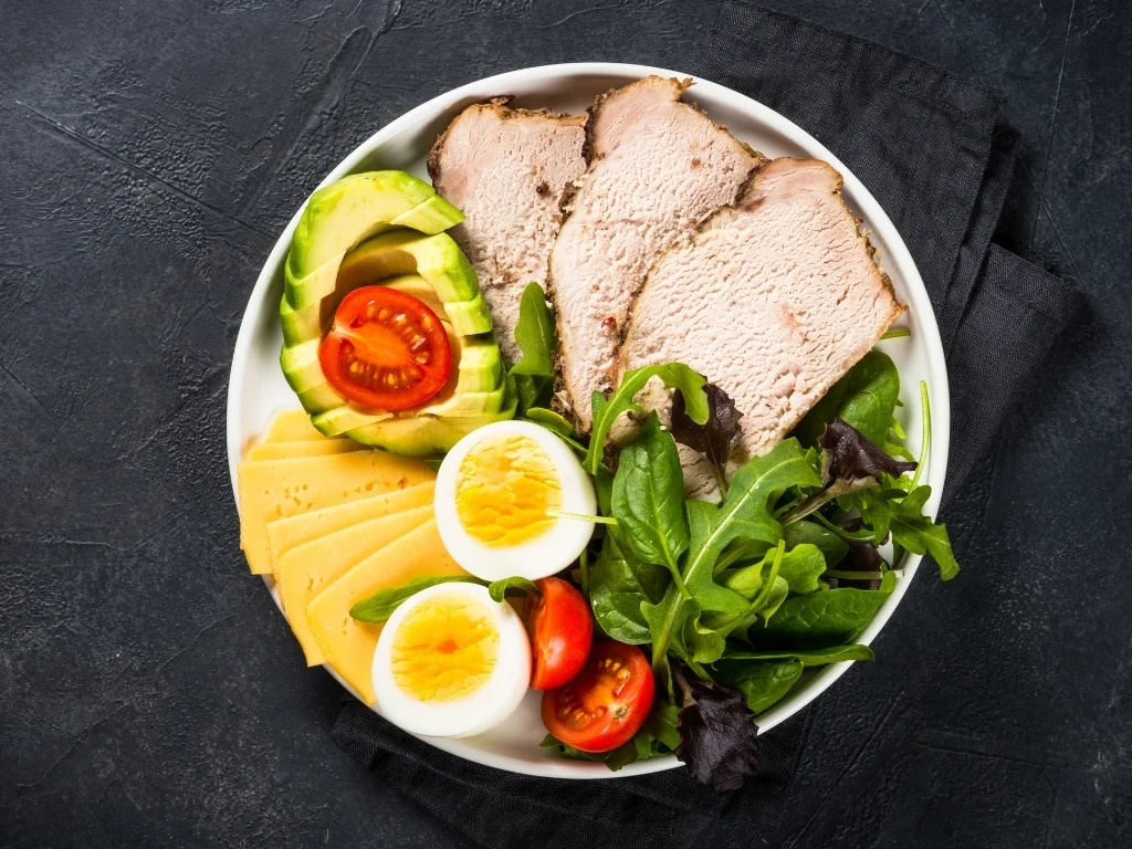 Plate of well-portioned healthy foods on a black stone table