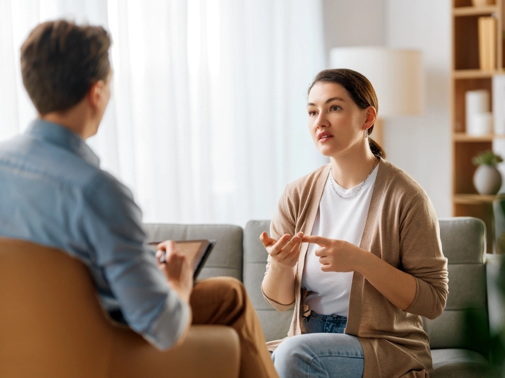 Woman speaking with a male therapist during a consultation