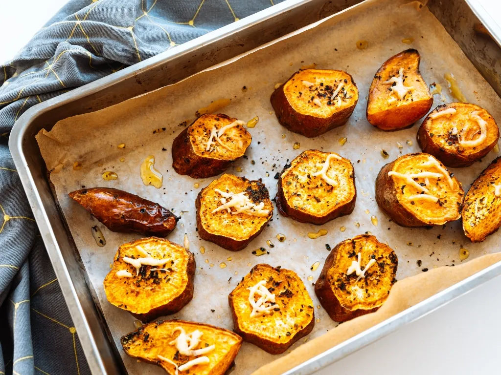 Tray of roasted sweet potato slices with cheese