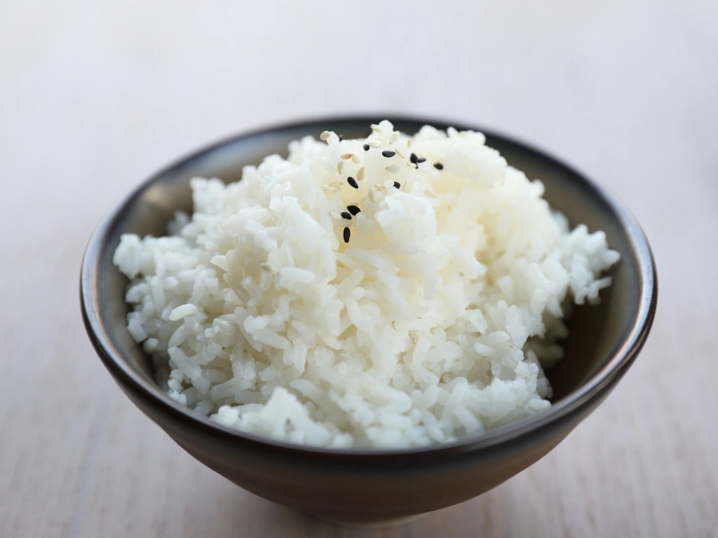 Bowl of steamed white rice topped with a sprinkle of black and white sesame seeds