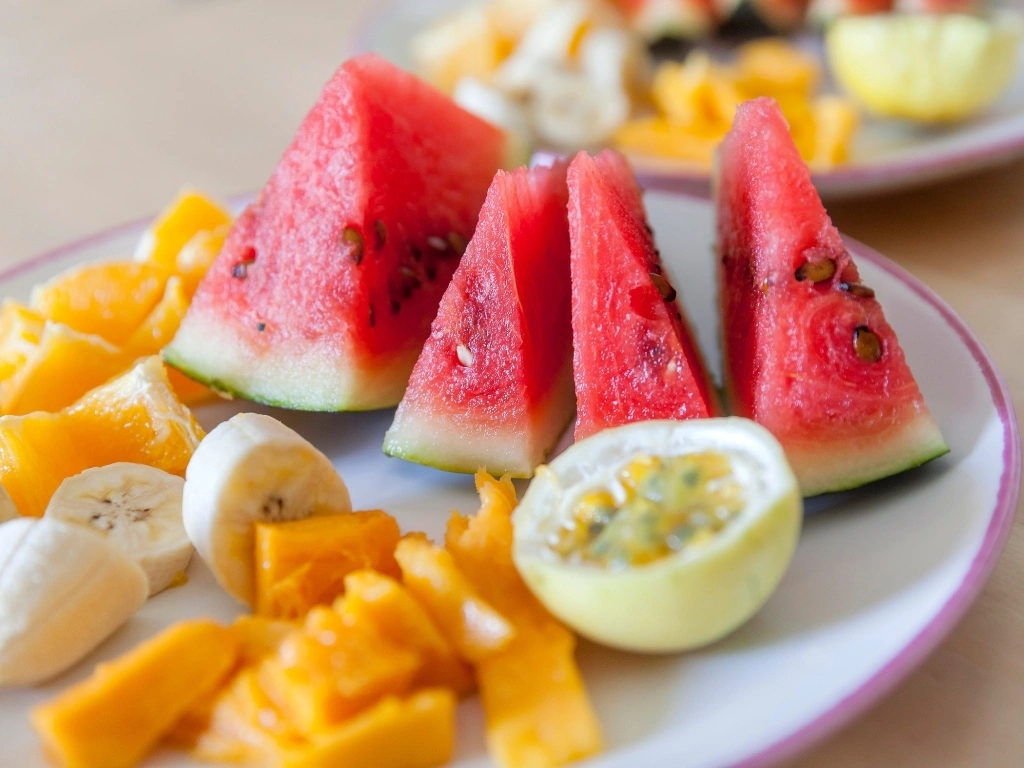 Slices of watermelon, banana, and papaya on a plate
