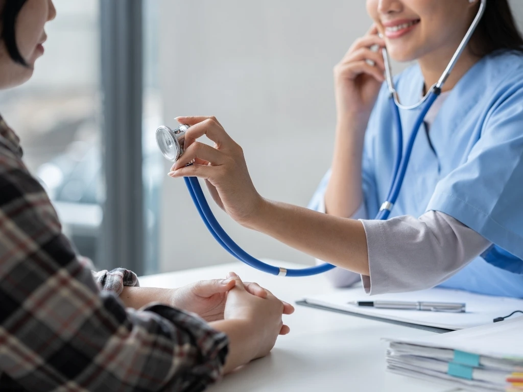 female doctor using a stethoscope to examine a patient