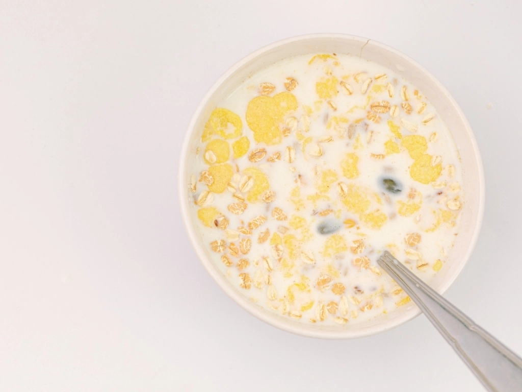milk in a Bawl of cereal with a spoon