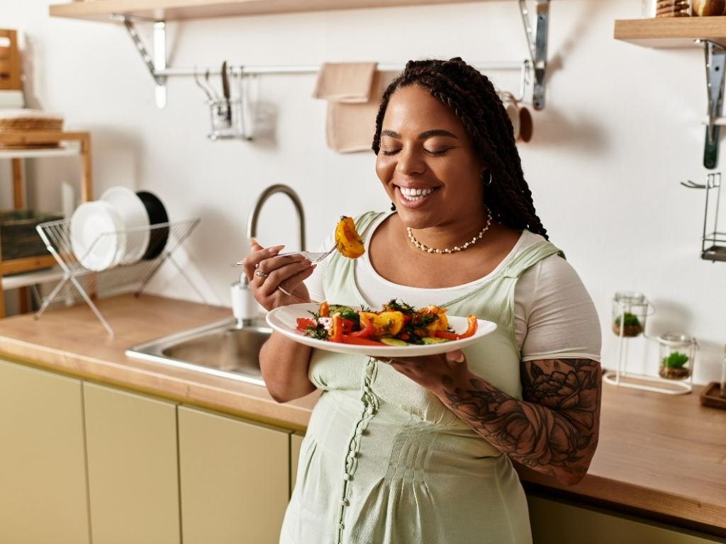 Young woman enjoying a healthy salad in her cozy kitchen during lunch