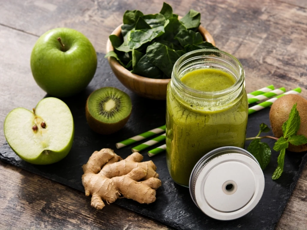 Glass of green protein smoothie, next to key ingredients