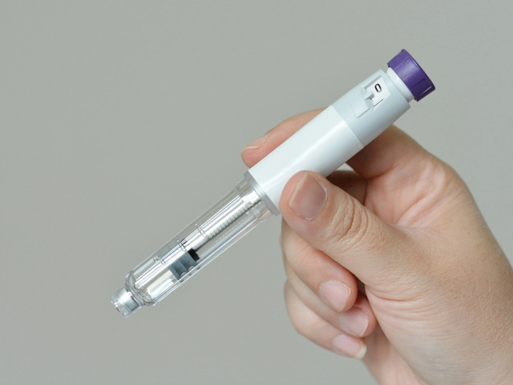 Hand holding a medical injector pen
