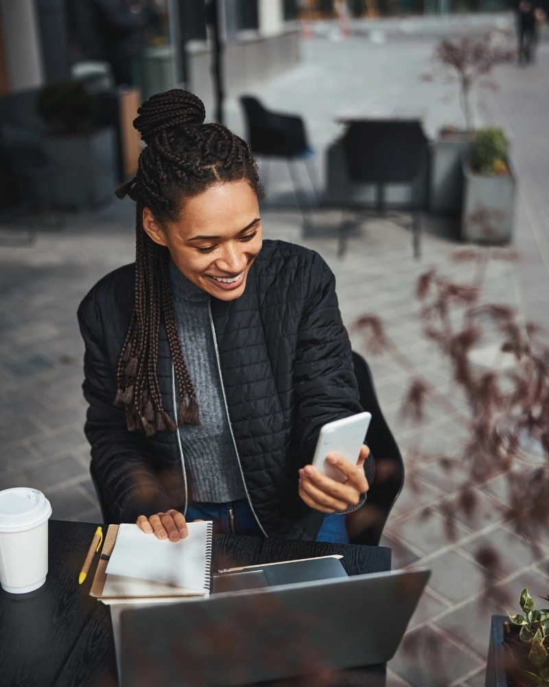 Contented young woman spending time online and smiling