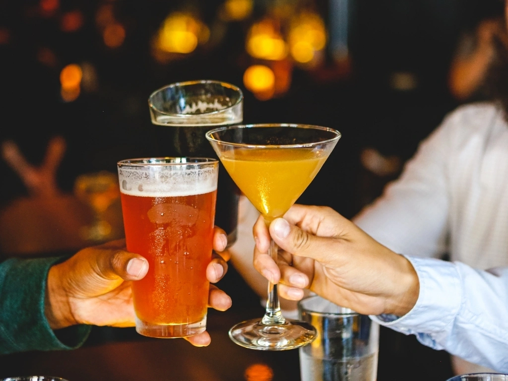 Three people raising their glasses in a toast