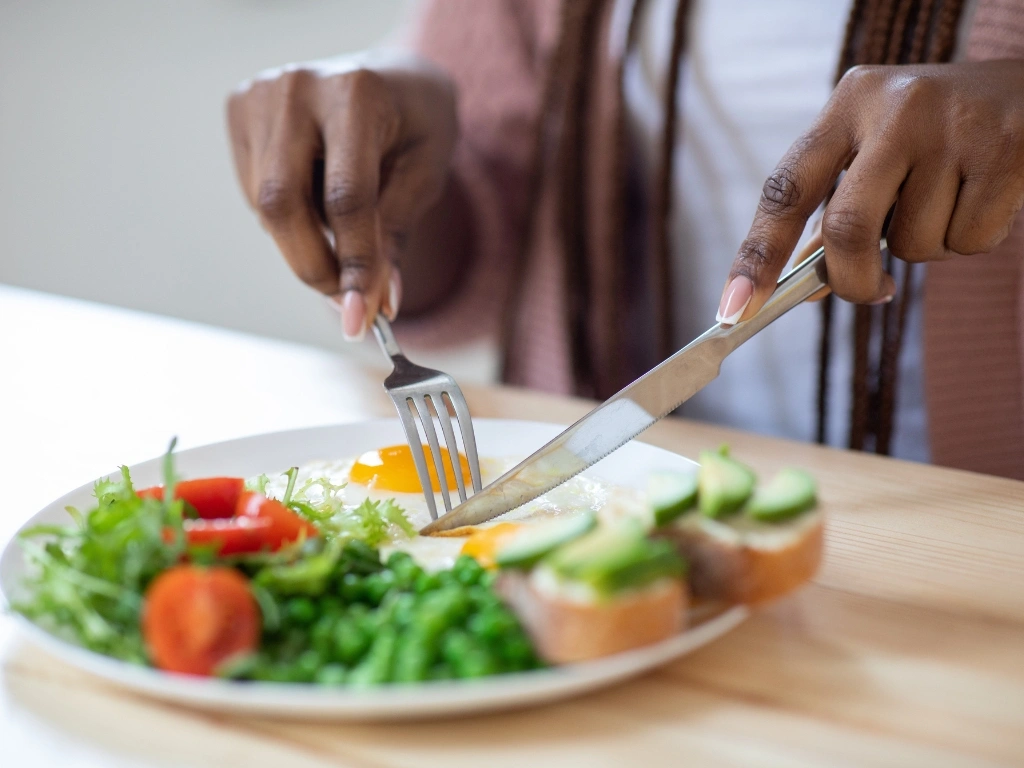 Woman eating a salad with a sunny-side-up egg