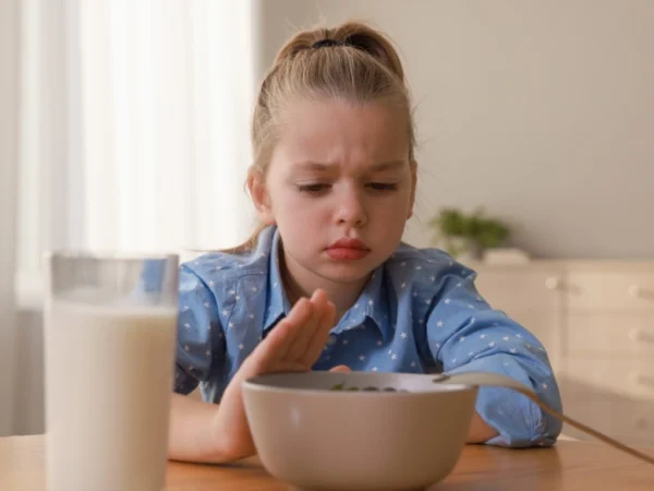 Child refusing a bowl of food during mealtime
