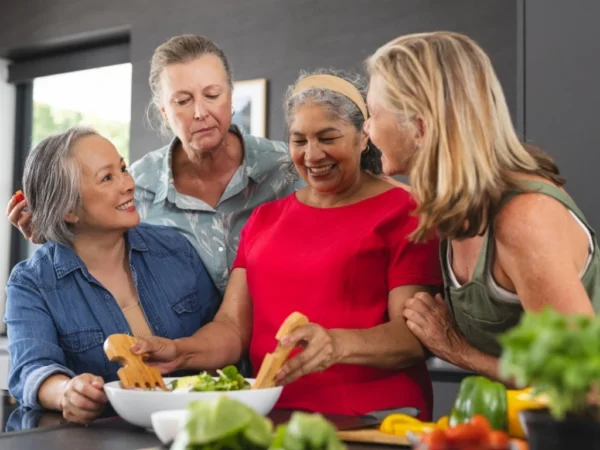 Group of mature women preparing salad together